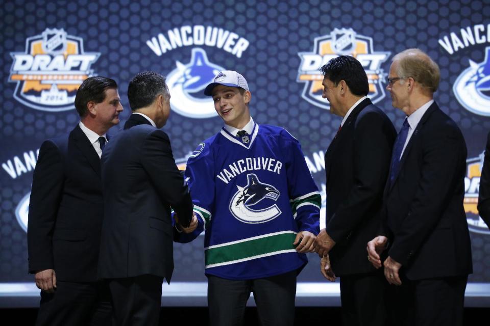 Jake Virtanen shakes hands with Vancouver Canucks officials after being chosen sixth overall during the first round of the NHL hockey draft, Friday, June 27, 2014, in Philadelphia. (AP Photo/Matt Slocum)