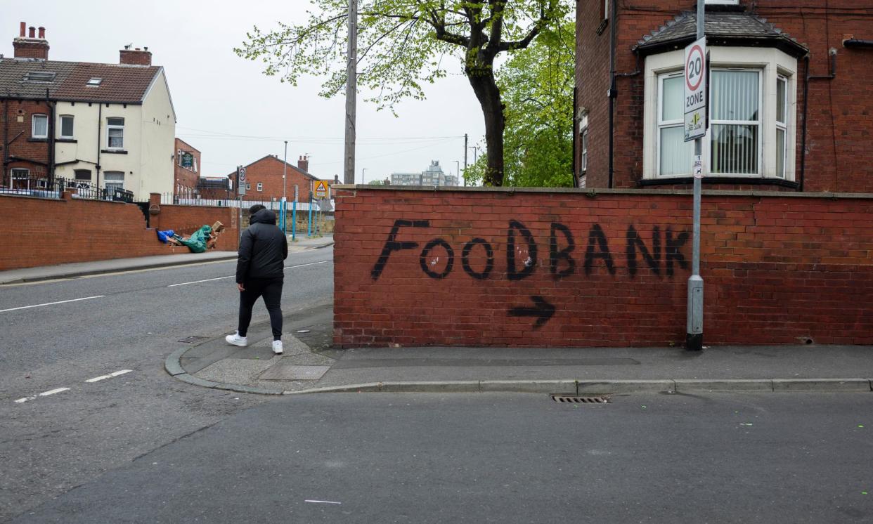 <span>Graffiti points towards a local food bank in Harehills, one of the most deprived areas of Leeds.</span><span>Photograph: Daniel Harvey Gonzalez/In Pictures/Getty Images</span>