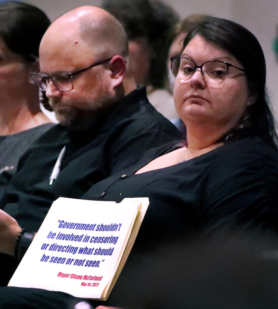 Tiffany Fee holds up a sign with a quote attributed to Murfreesboro Mayor Shane McFarland during a Rutherford County Library System, Library Board meeting on Monday, Aug. 28, 2023, where books were banned. During the meeting Fee and her husband Matt Fee both spoke out against banning books in the public library, during the public comment section of the meeting.