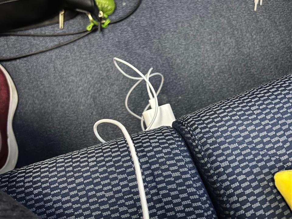 My white charger plugged into the power port located on the front of the seat.