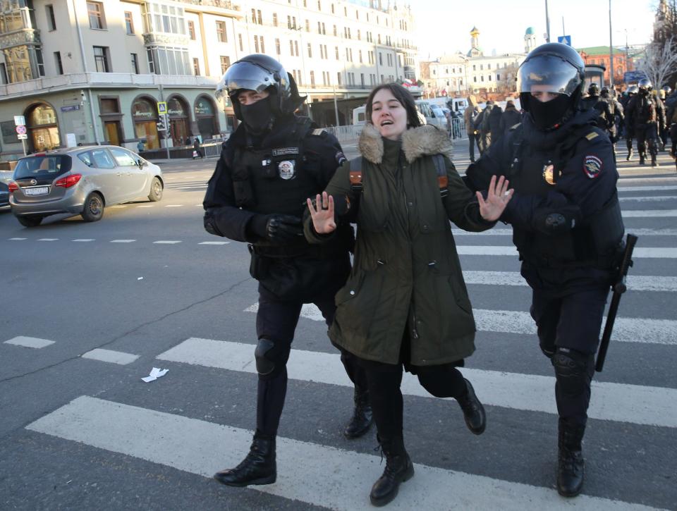 Russian police officers detain a woman during an unsanctioned protest rally against the military invasion on Ukraine