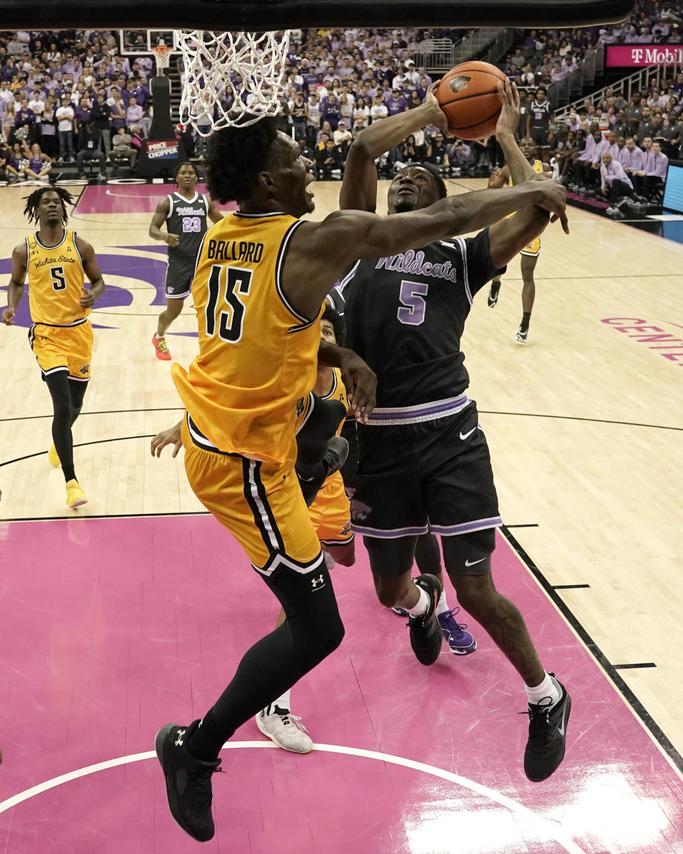 Kansas State guard Cam Carter (5) shoots under pressure from Wichita State center Quincy Ballard (15) during the first half of an NCAA college basketball game Thursday, Dec. 21, 2023, in Kansas City, Mo. (AP Photo/Charlie Riedel)