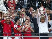 Arsenal manager Arsene Wenger (R) lifts the trophy as he celebrates with his players their victory against Hull City in their FA Cup final at Wembley Stadium in London, May 17, 2014. REUTERS/Eddie Keogh