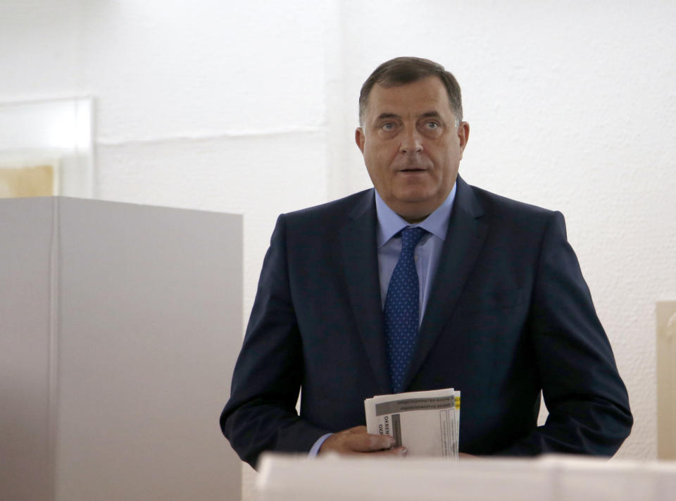 President of the Republic of Srpska Milorad Dodik carries his ballot at a polling station in Laktasi, northwest of Sarajevo, Bosnia, Sunday, Oct. 7, 2018. Bosnians were voting Sunday in a general election that could install a pro-Russian nationalist to a top post and cement the ethnic divisions of a country that faced a brutal war 25 years ago. (AP Photo/Darko Vojinovic)