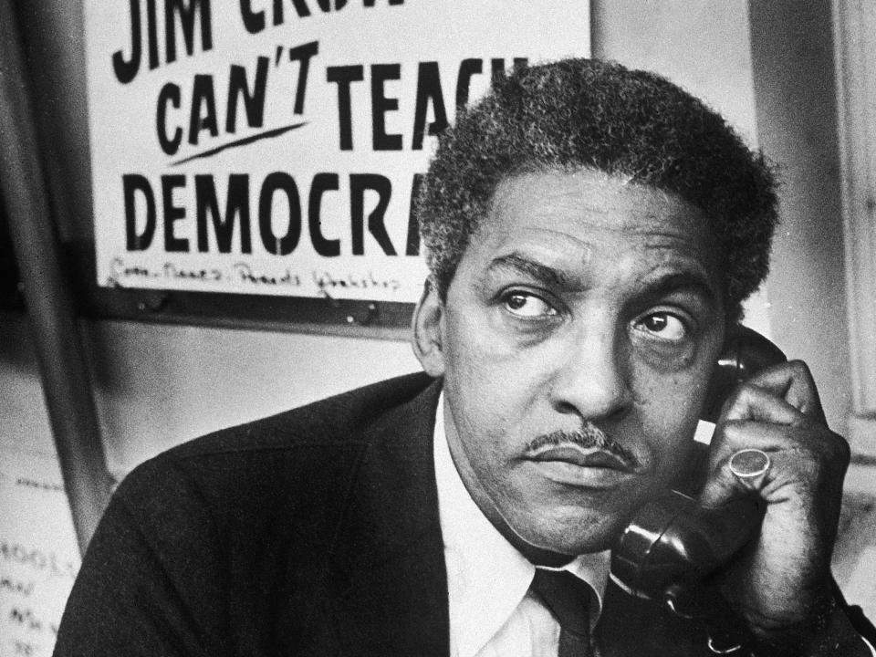 Civil Rights activist Bayard Rustin, spokesman for the Citywide Committee for Integration, talks on the phone at the organization's headquarters at Silcam Presbyterian Church, Brooklyn, New York.