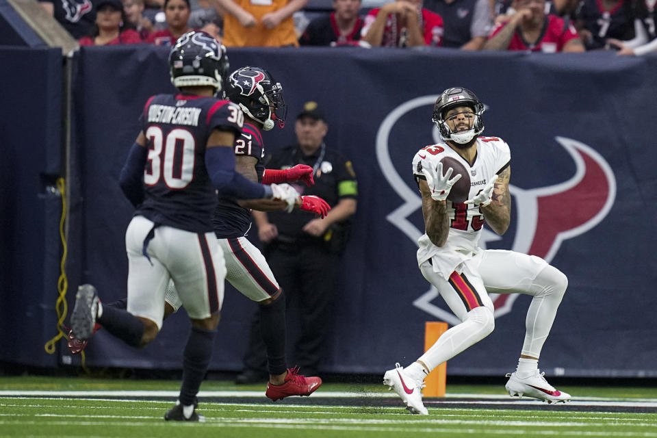 Tampa Bay Buccaneers wide receiver Mike Evans (13) makes a catch in front of Houston Texans cornerback Steven Nelson (21) and safety DeAndre Houston-Carson (30) during the second half of an NFL football game, Sunday, Nov. 5, 2023, in Houston. (AP Photo/Eric Gay)