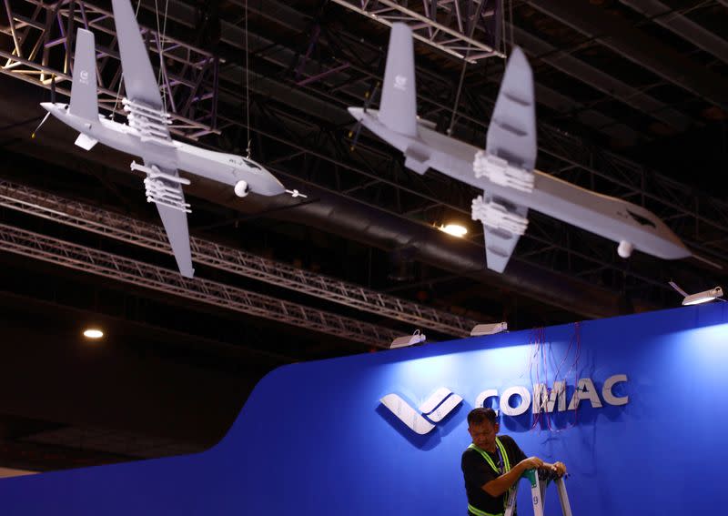 A worker fixes cables at the Comac booth ahead of the Singapore Airshow at Changi Exhibition Centre in Singapore