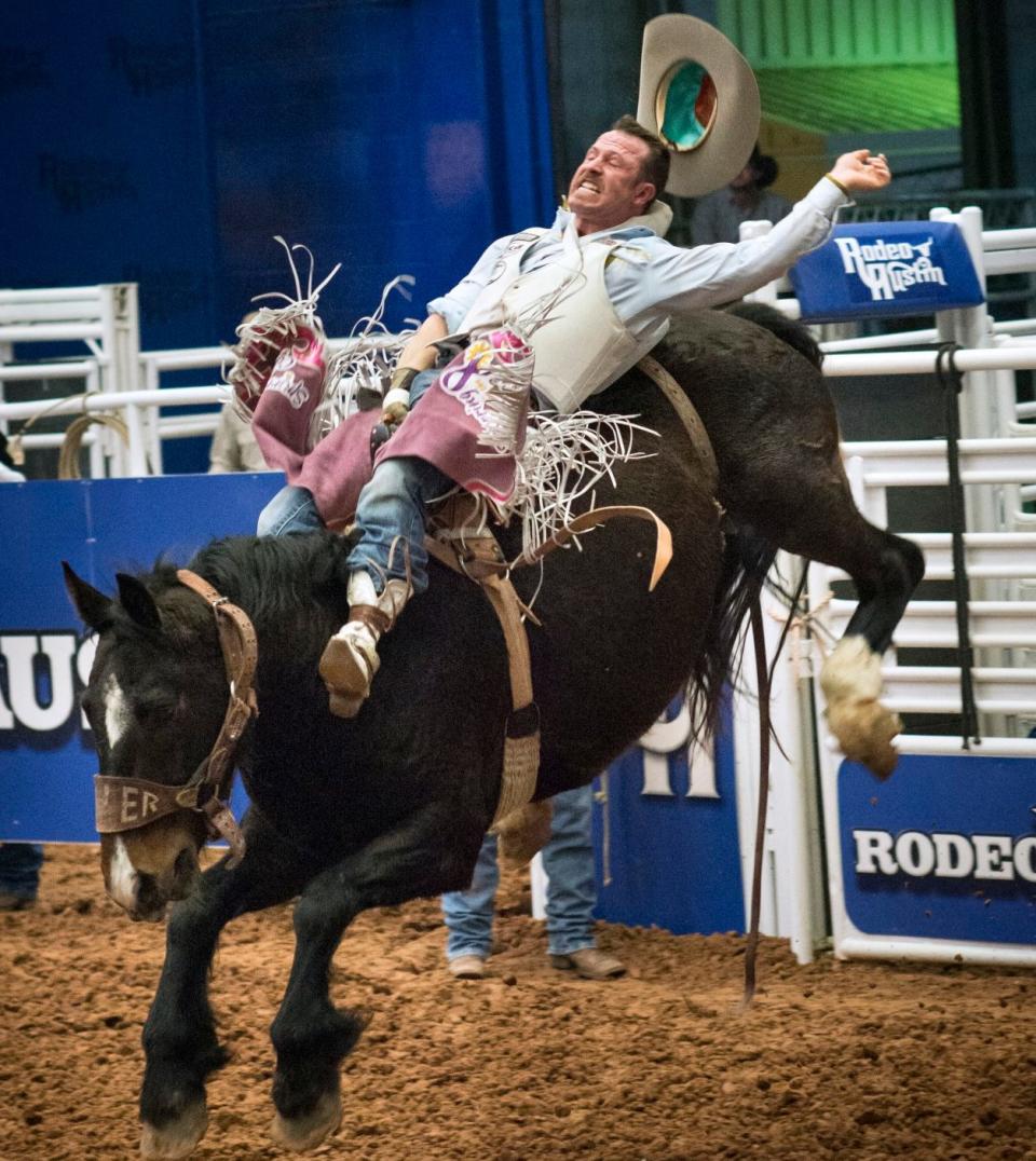 Καουμπόη bronc καβαλάρης σε άλογο που κουνάει κατά τη διάρκεια του Austin Rodeo