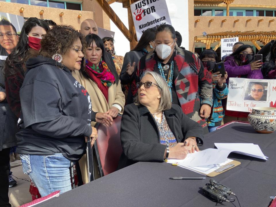 FILE - New Mexico Gov. Michelle Lujan Grisham, center, prepares to sign legislation aimed at addressing cases of missing and slain Native Americans during a ceremony in Albuquerque, N.M. on Thursday, Feb. 24, 2022. New Mexico's governor isn't backing down on her decision to nominate a former tribal leader who once faced sexual assault charges to head the state's Indian Affairs Department. (AP Photo/Susan Montoya Bryan,File)