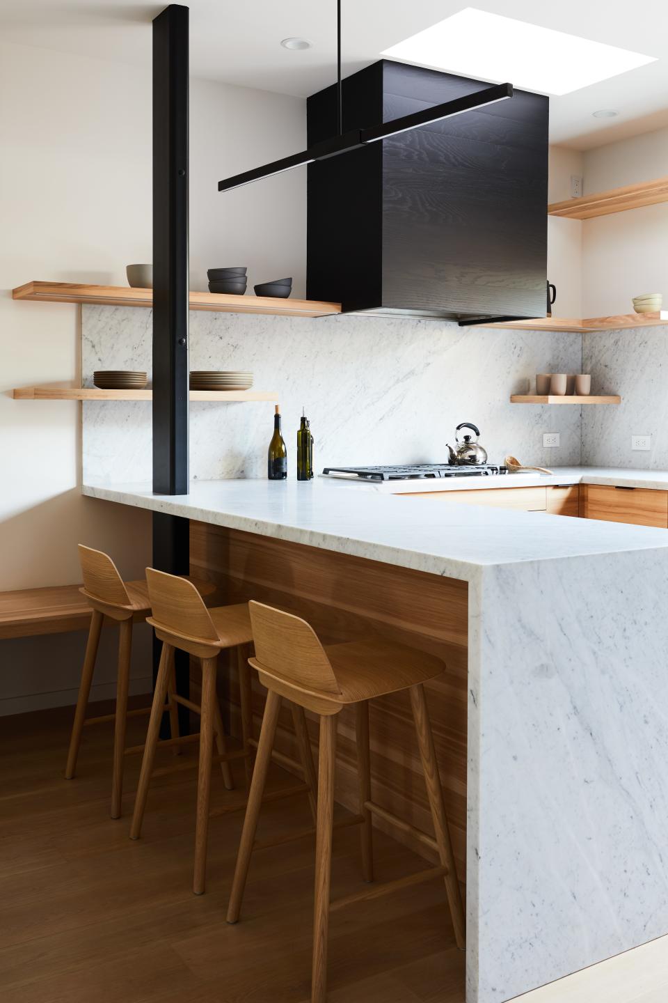 AFTER: Things were switched up by installing open cabinetry and sticking to a palette of black, white, and wood.