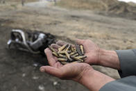 An Afghan security force hold bullet shell a day after an attack near the Bagram Air Base, north of Kabul, Afghanistan, Tuesday, April 9, 2019. Three American service members and a U.S. contractor were killed when their convoy hit a roadside bomb on Monday near the main U.S. base in Afghanistan, the U.S. forces said. The Taliban claimed responsibility for the attack. (AP Photo/Rahmat Gul)