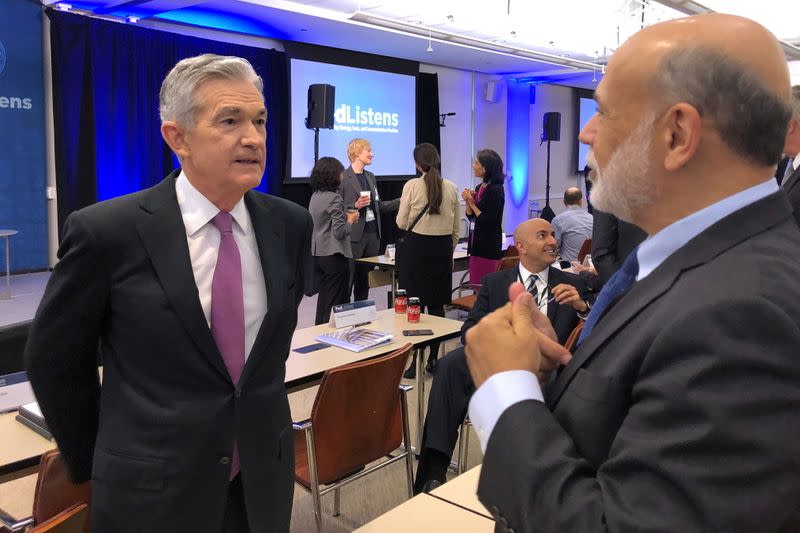 FILE PHOTO: Federal Reserve Chair Jerome Powell speaks with former Fed Chairman Ben Bernanke at a conference on monetary policy at the Federal Reserve Bank of Chicago