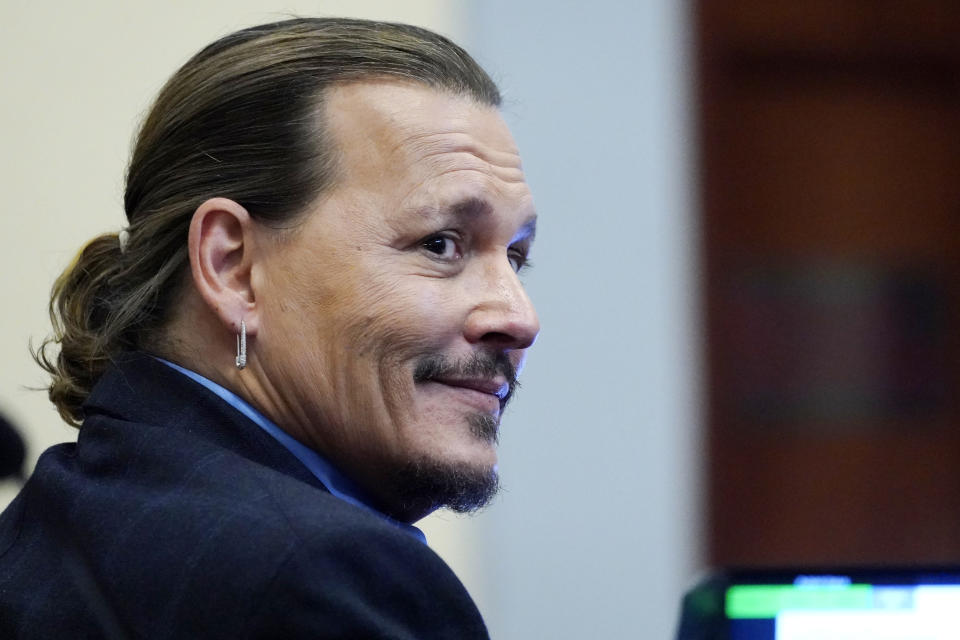 El actor Johnny Depp escucha en el Tribunal de Circuito del Condado de Fairfax, el lunes 2 de mayo de 2022 en Fairfax, Virginia. Depp demandó por difamación a su exesposa, Amber Heard, por un artículo de opinión que ella escribió en 2018 en el que se refirió a sí misma como una "figura pública que representa el abuso doméstico". (Foto AP/Steve Helber, Pool)