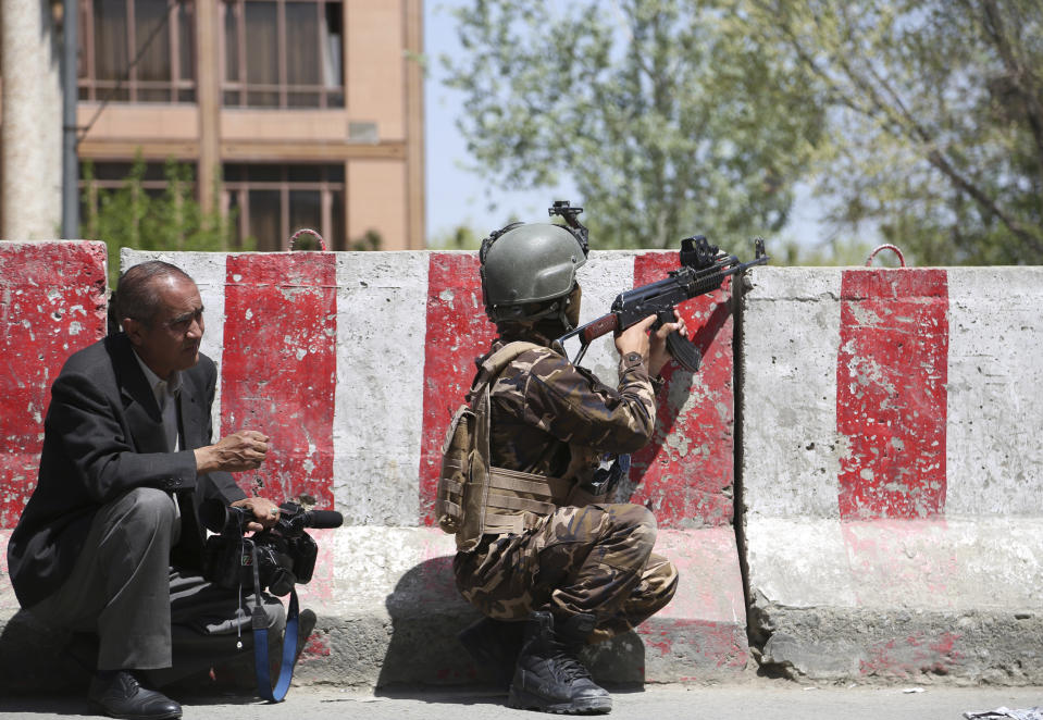 An Afghan Security personnel aims his weapon outside the Telecommunication Ministry during a gunfight with insurgents in Kabul, Afghanistan, Saturday, April 20, 2019. Afghan officials say an explosion has rocked the telecommunications ministry in the capital city of Kabul. Nasart Rahimi, a spokesman for the interior ministry, said Saturday the blast occurred during a shootout with security forces. (AP Photo/Rahmat Gul)