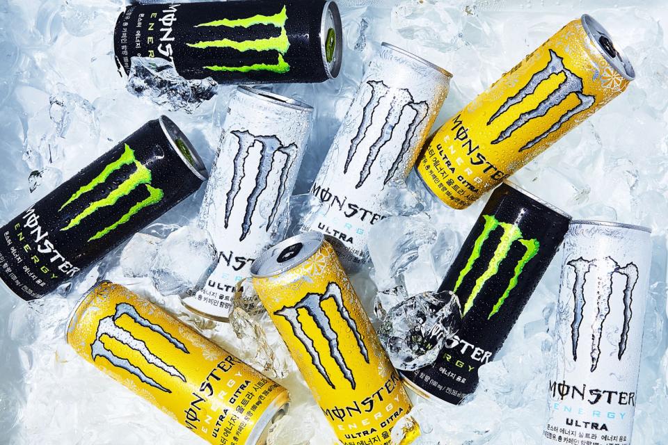 Black, white, and yellow Monster Energy cans on ice.