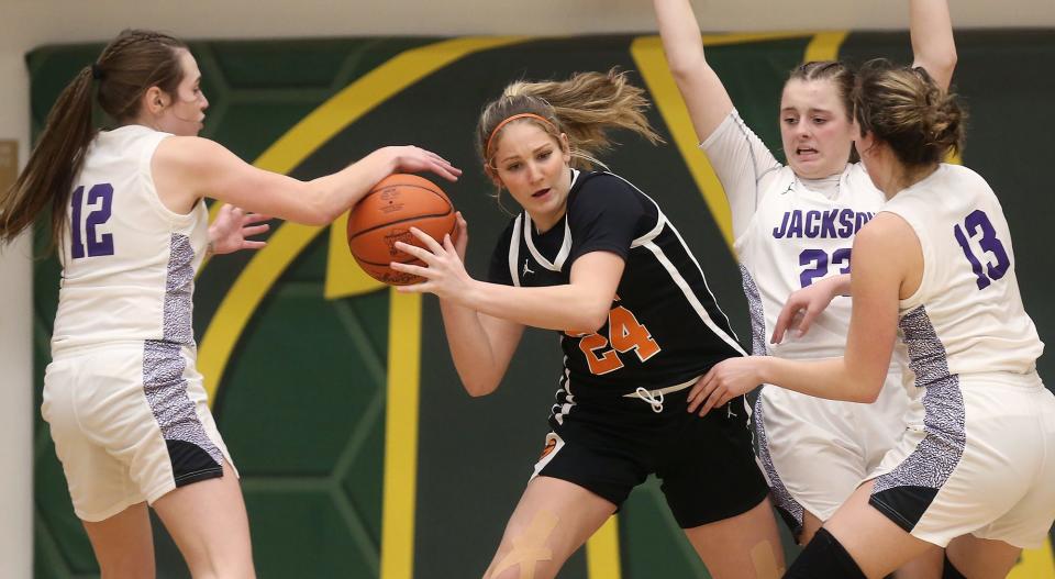 Green's Jenna Slates battles for the ball with a host of Jackson players during the second half of a Division I regional semifinal basketball game on Tuesday.