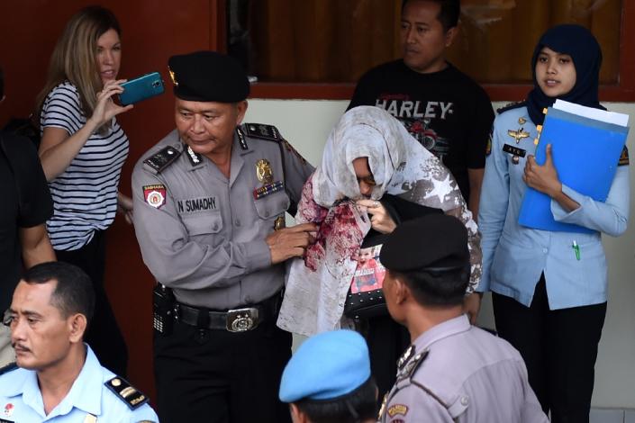 Corby was led out of the Bali villa, hidden under a scarf and wearing a pair of sunglasses, before being whisked away in a convoy that included armoured vehicles. (AFP Photo/SONNY TUMBELAKA)