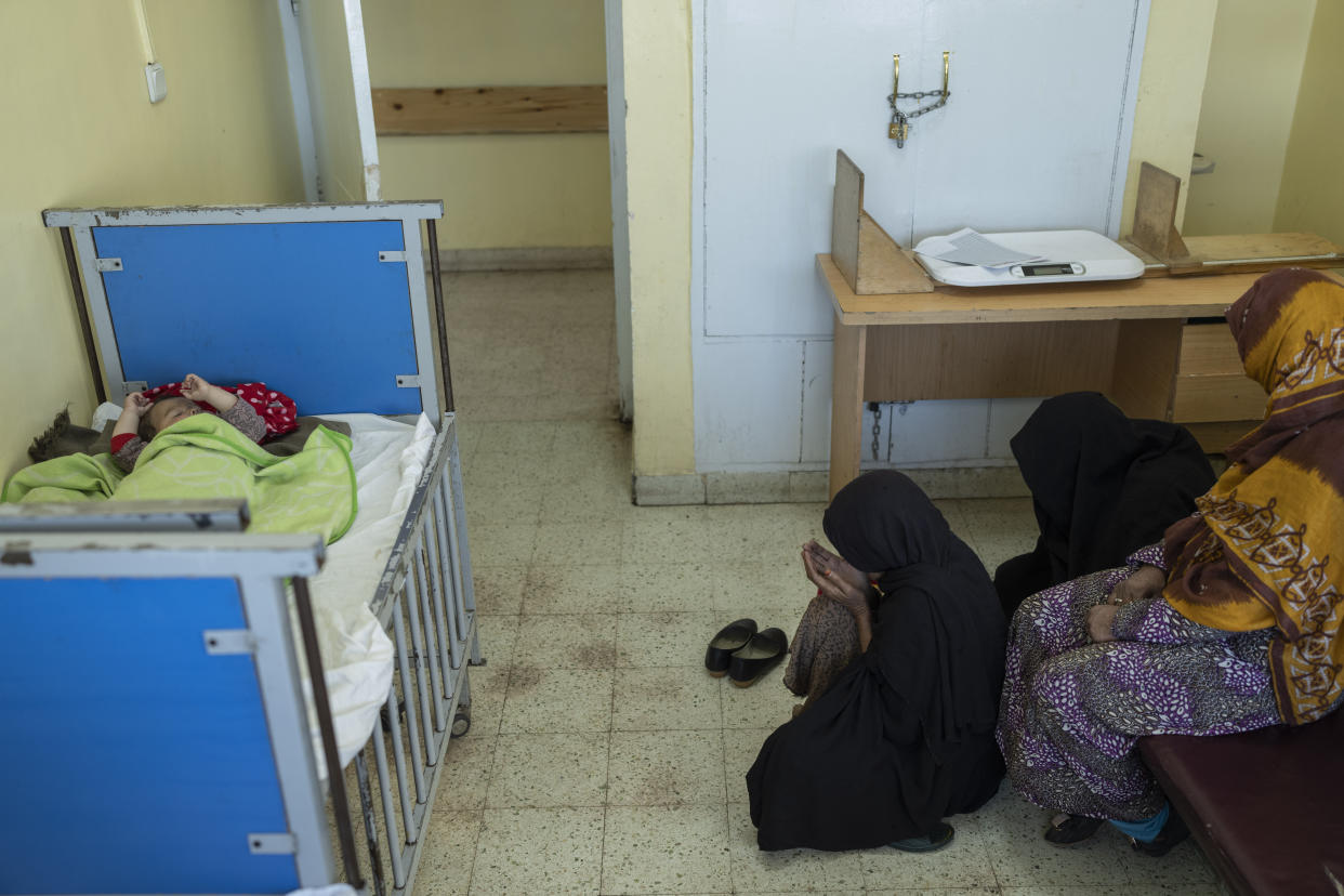 Women pray while a child is undergoing treatment for malnutrition in the Indira Gandhi Children's Hospital in Kabul, Afghanistan, on Wednesday, Dec. 8, 2021. Afghanistan's health care system, is on the brink of collapse and to function only with a lifeline from aid organisations. (AP Photo/Petros Giannakouris)