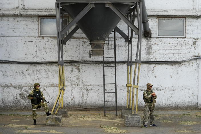 FILE - During a trip organized by the Russian Ministry of Defense, Russian soldiers stand guard as foreign journalists visit a grain elevator in Melitopol, southern Ukraine, Thursday, July 14, 2022. An investigation by The Associated Press shows a Russian-run smuggling operation has been transporting grain from occupied regions of Ukraine by train and truck to ports in Crimea, where it is shipped to buyers in the Middle East. (AP Photo, File)