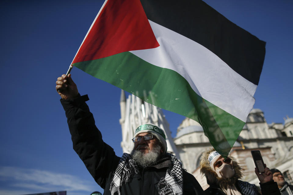 Protesters, one holding a Palestinian flag, participate in a rally against the proposed U.S. Mideast peace plan following Friday's Muslim prayers outside Fatih mosque in Istanbul, Friday, Jan. 31, 2020. U.S. President Donald Trump's Mideast plan would create a disjointed Palestinian state with a capital on the outskirts of east Jerusalem, beyond the separation barrier built by Israel. The rest of the Jerusalem, including the Old City, would remain Israel's capital. (AP Photo/Emrah Gurel)