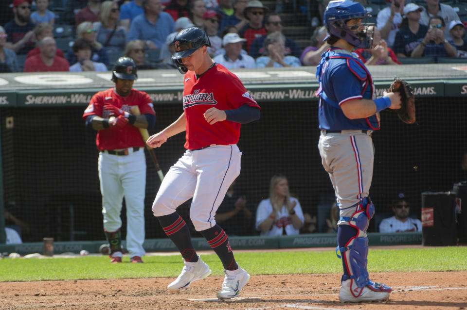 Cleveland Guardians' Will Brennan scores on a single by Steven Kwan as Texas Rangers' Austin Hedges, right, waits during the fourth inning of a baseball game in Cleveland, Sunday, Sept. 17, 2023. (AP Photo/Phil Long)