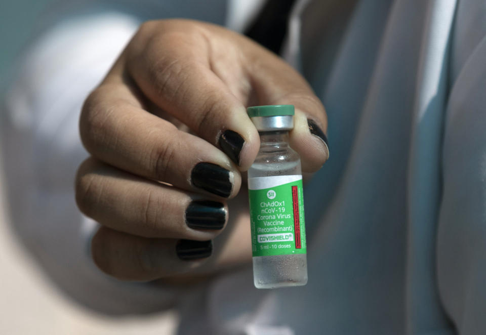 A healthcare worker shows a vial of the Oxford-AstraZeneca vaccine for COVID-19 under a tent where people are getting vaccinated at the "Clinica da Familia Estacio de Sa" in Rio de Janeiro, Brazil, Wednesday, Jan. 27, 2021. (AP Photo/Silvia Izquierdo)