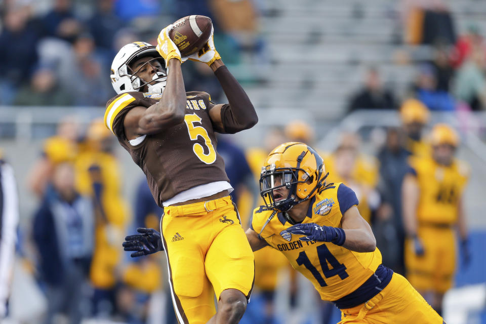 Wyoming wide receiver Isaiah Neyor (5) catches the ball in front of Kent State cornerback Elvis Hines (14) on a 42 yard touchdown reception during the first half of the Idaho Potato Bowl NCAA college football game, Tuesday, Dec. 21, 2021, in Boise, Idaho. (AP Photo/Steve Conner)