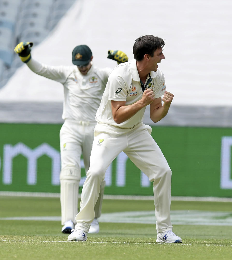 Australia's Pat Cummins, right celebrates the wicket of New Zealand's Henry Nicholls, left, during a cricket test match in Melbourne, Australia, Saturday, Dec. 28, 2019. (AP Photo/Andy Brownbill)