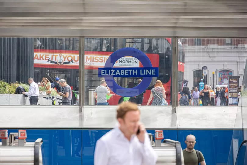 A man talks on the phone at the entrance to Liverpool Street Elizabeth Line Station