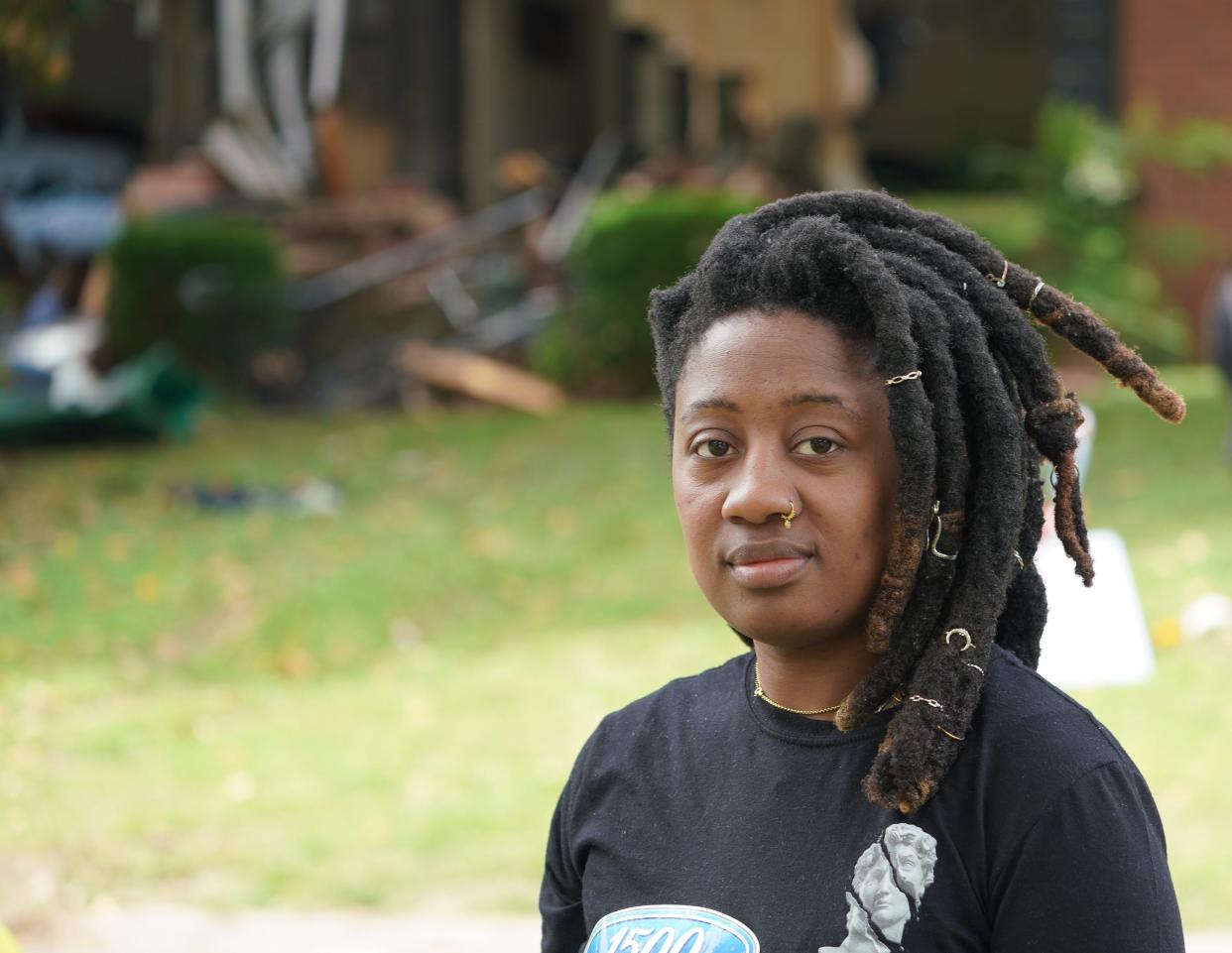 Neighbor Rissa Reign poses for a picture in front of a Charlotte, North Carolina, home destroyed by police after officers serving a warrant on a man inside on April 29, 2024, came under fire, leaving four officers dead.