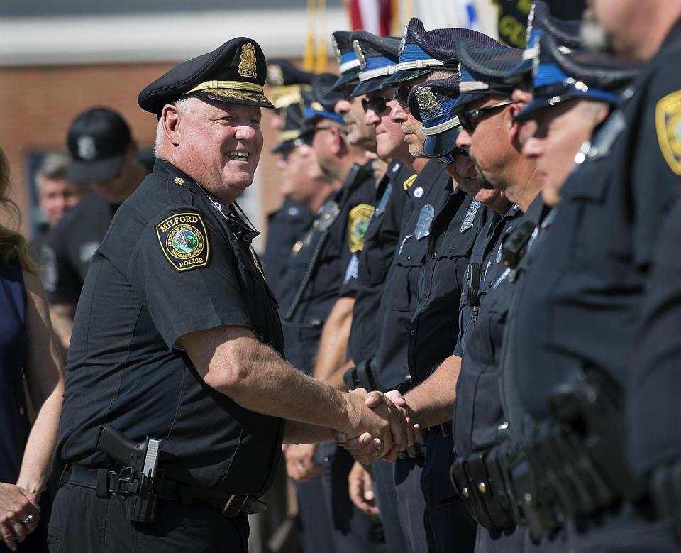 Outgoing Milford Police Chief Thomas O'Loughlin shakes hands with officers as he leaves Milford Police Headquarters following a send-off ceremony in June 2019. O'Loughlin's lawsuit against the town and two former Select Board members has been settled.