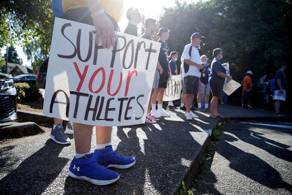 Athlete Zackery Schmeichel of Hazen High School holds a sign that reads "support your athletes" as people gather for a march and rally organized by Student Athletes of Washington (SAW), a group that formed to protest the postponement of fall sports due to COVID-19, at the state capitol in Olympia, Washington on September 3, 2020. (Photo by JASON REDMOND/AFP via Getty Images)