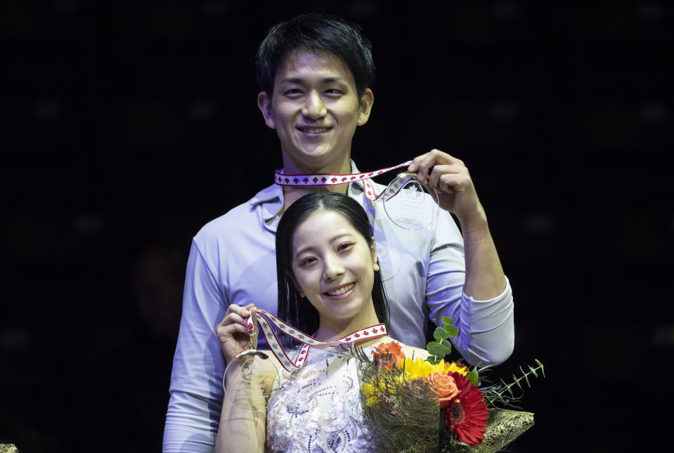 Pairs gold medalists Riku Miura and Ryuichi Kihara of Japan hold up their medals during victory ceremonies at the Skate Canada International figure skating competition in Mississauga, Ontario, on Saturday, Oct. 29, 2022. (Paul Chiasson/The Canadian Press via AP)