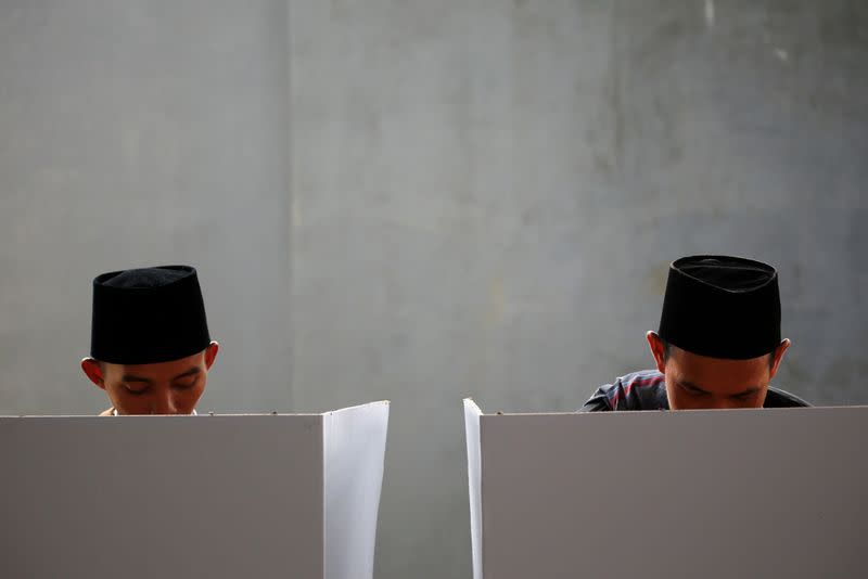 FILE PHOTO: Voters mark their ballots at a polling booth during elections in Bogor, West Java
