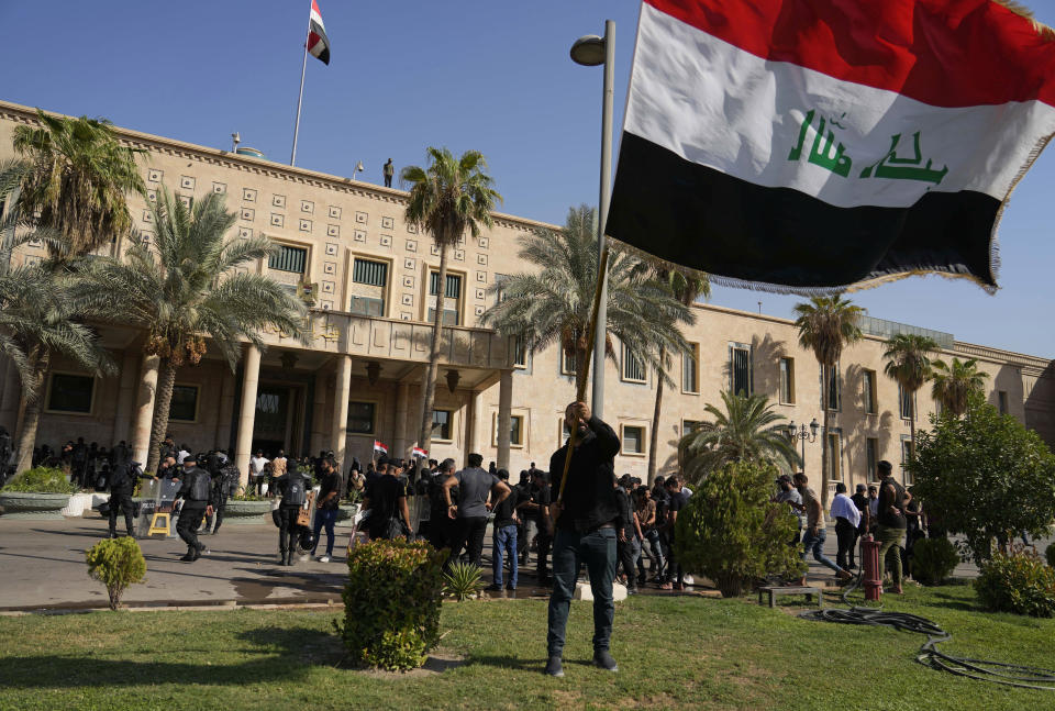 Supporters of Shiite cleric Muqtada al-Sadr demonstrate in the grounds of the Government Palace in Baghdad, Iraq, Monday, Aug. 29, 2022. Al-Sadr, a hugely influential Shiite cleric announced he will resign from Iraqi politics and his angry followers stormed the government palace in response. The chaos Monday sparked fears that violence could erupt in a country already beset by its worst political crisis in years. (AP Photo/Hadi Mizban)