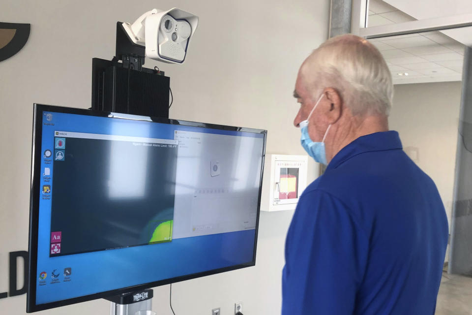 Roger Penske has his temperature taken at a screening station at Indianapolis Motor Speedway in Indianapolis, Thursday, July 2, 2020. Penske has spent the six months since he bought Indianapolis Motor Speedway transforming the facility. He's spent millions on capital improvements to the 111-year-old national landmark and finally gets to showcase some of the upgrades this weekend as NASCAR and IndyCar share the venue in a historic doubleheader. (AP Photo/Jenna Fryer)