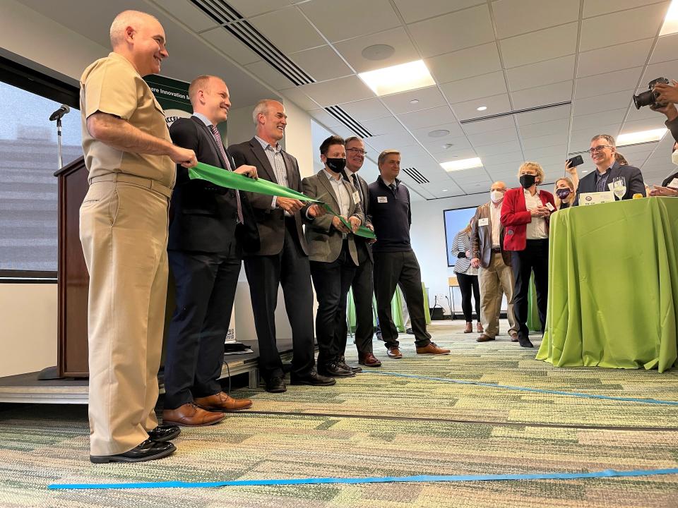 U.S. Rep. Rick Larsen, D-Everett, cuts a ribbon on a new innovation lab in Seattle with other leaders who helped create it. The lab includes a direct line to the different branches of the military.