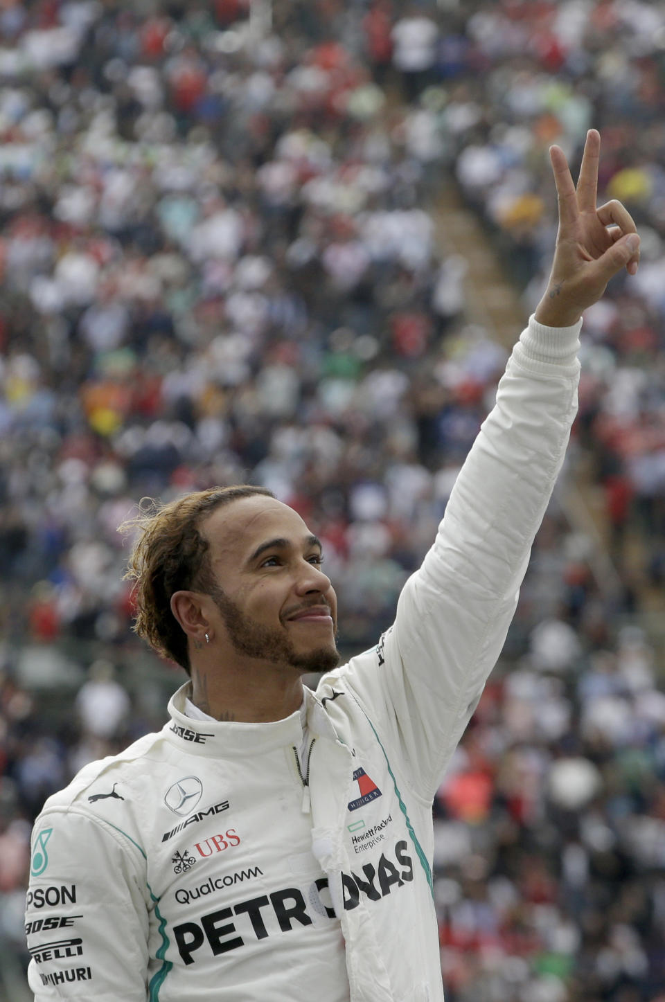Mercedes driver Lewis Hamilton, of Britain, flashes a victory sign after becoming Formula One champion in the Mexico Grand Prix auto race at the Hermanos Rodriguez racetrack in Mexico City, Sunday, Oct. 28, 2018. (AP Photo/Moises Castillo)
