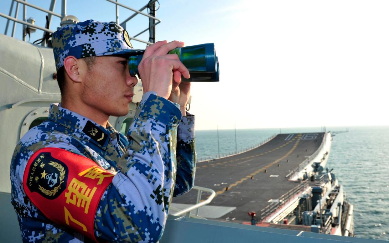 A naval soldier views through a pair of binoculars - Reuters