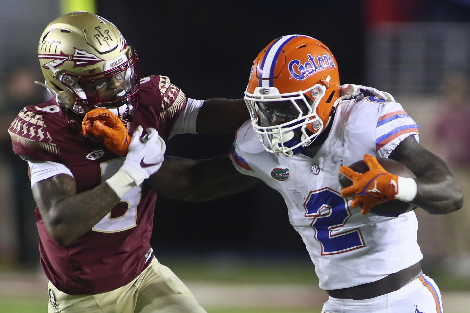 Florida running back Montrell Johnson Jr. (2) pushes off Florida State defensive back Renardo Green during the first quarter of an NCAA college football game Friday, Nov. 25, 2022, in Tallahassee, Fla. (AP Photo/Phil Sears)