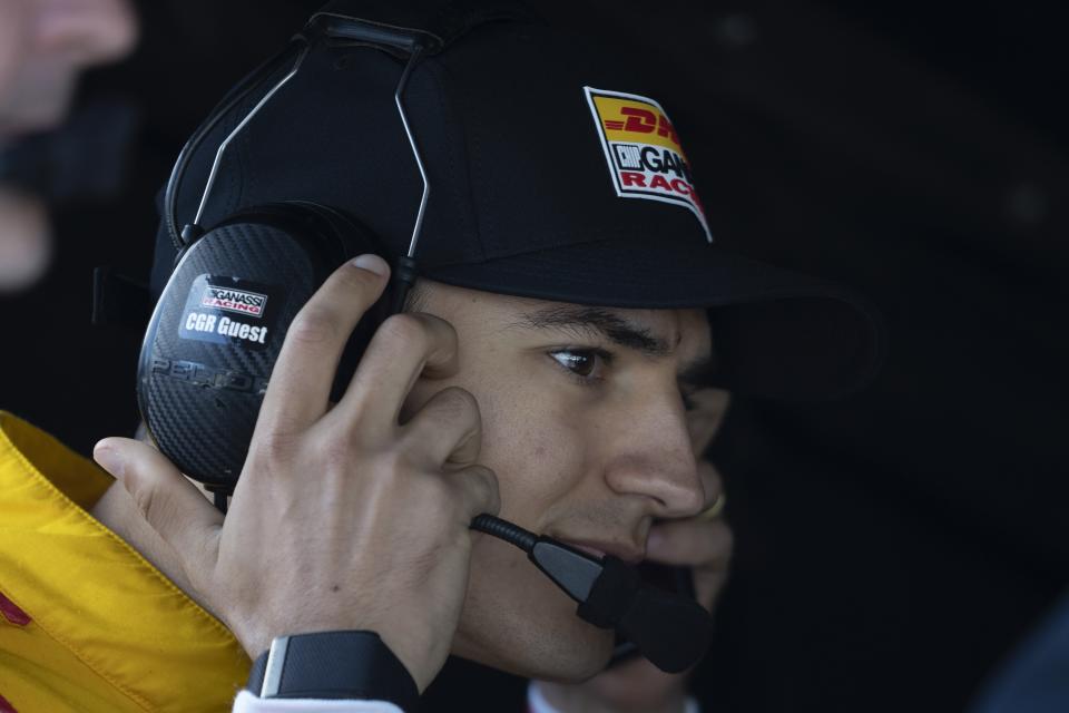 Alex Palou, of Spain, talks with his team during a practice session for the IndyCar Grand Prix auto race at Indianapolis Motor Speedway, Friday, May 10, 2024, in Indianapolis. (AP Photo/Darron Cummings)