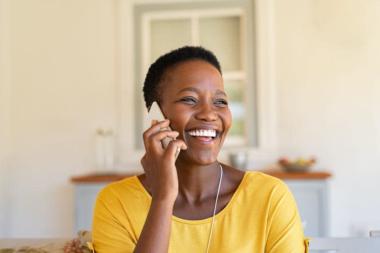 A woman smiling on the phone.