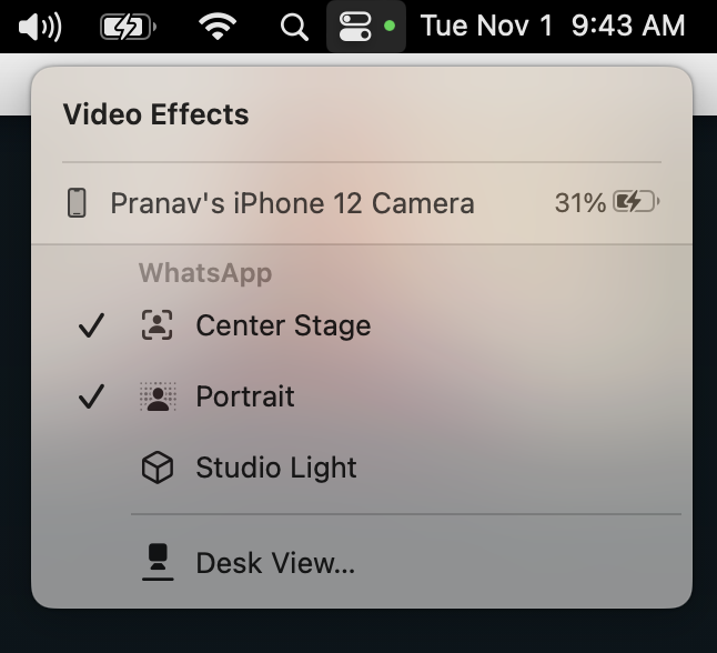 A dropdown menu on a computer screen shows that Pranav's iPhone 12 Camera is attached with the WhatsApp options of Center Stage, Portrait, Studio Light, and Desk View