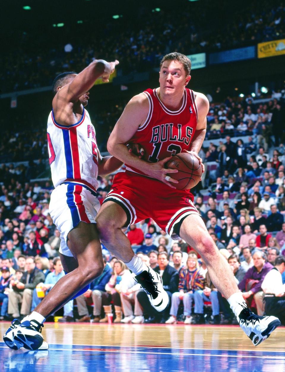 Luc Longley #13 of the Chicago Bulls drives against the Detroit Pistons on January 21, 1996 at the Palace of Auburn Hills in Auburn Hills, Michigan