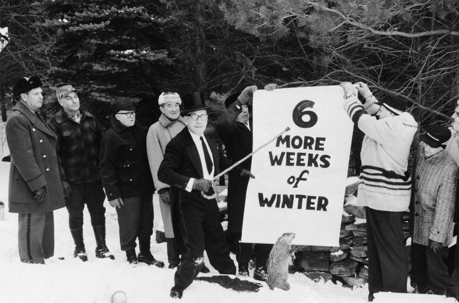 Sam Light, center, president of the Punxsutawney Groundhog Club, points to a sign held by members of the club in Gobbler’s Knob, Punxsutawney, Pennsylvania, Jan. 1961. They posed for the picture a few days before Groundhog Day, Feb. 2, with a stuffed stand-in for Punxsutawney Phil. (AP Photo)