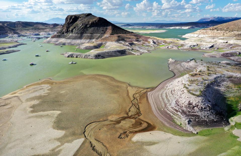 An aerial view of recently exposed lakebed (bottom L), with boats anchored near a 'bathtub ring' of mineral deposits left by higher water levels, at the drought-stricken Elephant Butte Reservoir on August 16, 2022, near Truth or Consequences, New Mexico. New Mexico’s largest reservoir is currently at 3.8 percent of its total capacity in spite of recent monsoon rains in the state. Experts say that despite monsoon rains delivering temporary relief to parts of the Southwest, the climate change-fueled megadrought remains entrenched in the West.