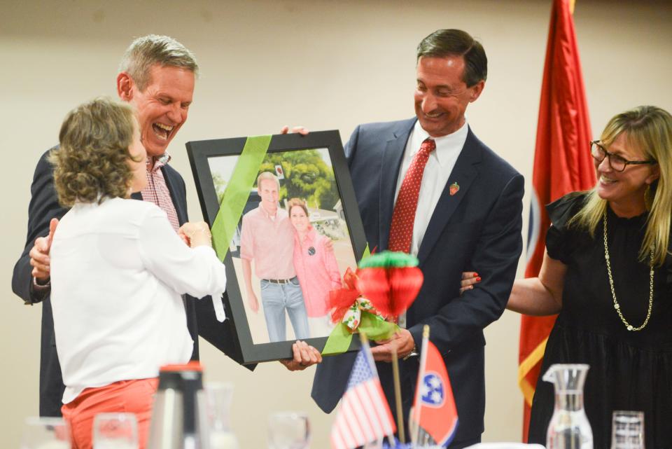 Gov. Bill Lee laughs as First Lady Maria points out he's wearing the same shirt as they receive a painting depicting their first apperance at the festival during the 86th annual West Tennessee Strawberry Festival Governor's Luncheon in Humboldt, Tenn., on Friday, May 10, 2024.