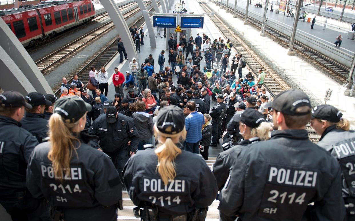 A group of refugees headed for Sweden wait after being stopped by police at the central station in Luebeck, Germany