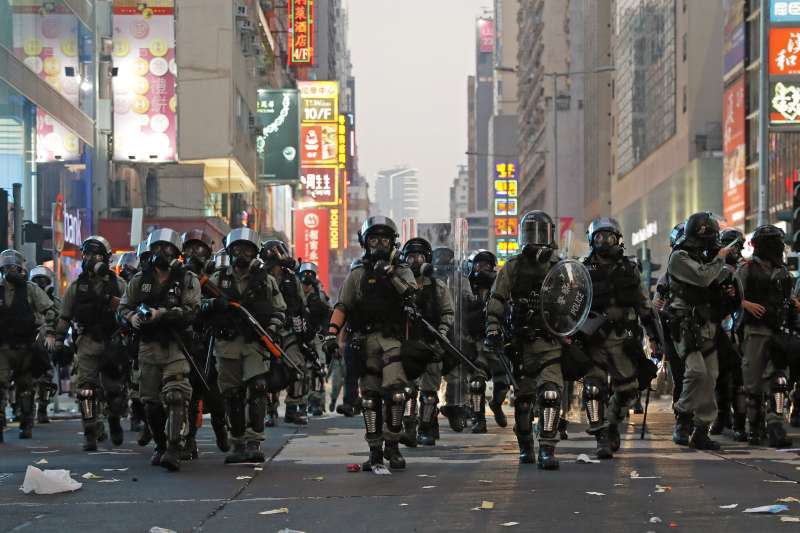 香港反送中抗爭一週年：2019年10月1日，防暴警察上街掃蕩堵路的示威者。（AP）