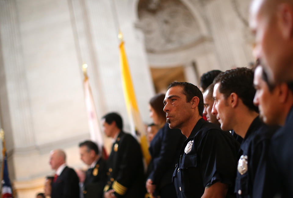 SAN FRANCISCO, CA - MARCH 26:  San Francisco firefighters look on during a remembrance ceremony held for San Francisco firefighters who have died of cancer on March 26, 2014 at San Francisco City Hall in San Francisco, California. Over two hundred pairs of boots were displayed on the steps inside San Francisco City Hall to symbolize the 230 San Francisco firefighters who have died of cancer over the past decade. According to a study published by the National Institute for Occupational Safety and Health, (NIOSH)  findings indicate a direct correlation between exposure to carcinogens like flame retardants and higher rate of cancer among firefighters.  The study showed elevated rates of respiratory, digestive and urinary systems cancer and also revealed that participants in the study had high risk of mesothelioma, a cancer associated with asbestos exposure.  (Photo by Justin Sullivan/Getty Images)